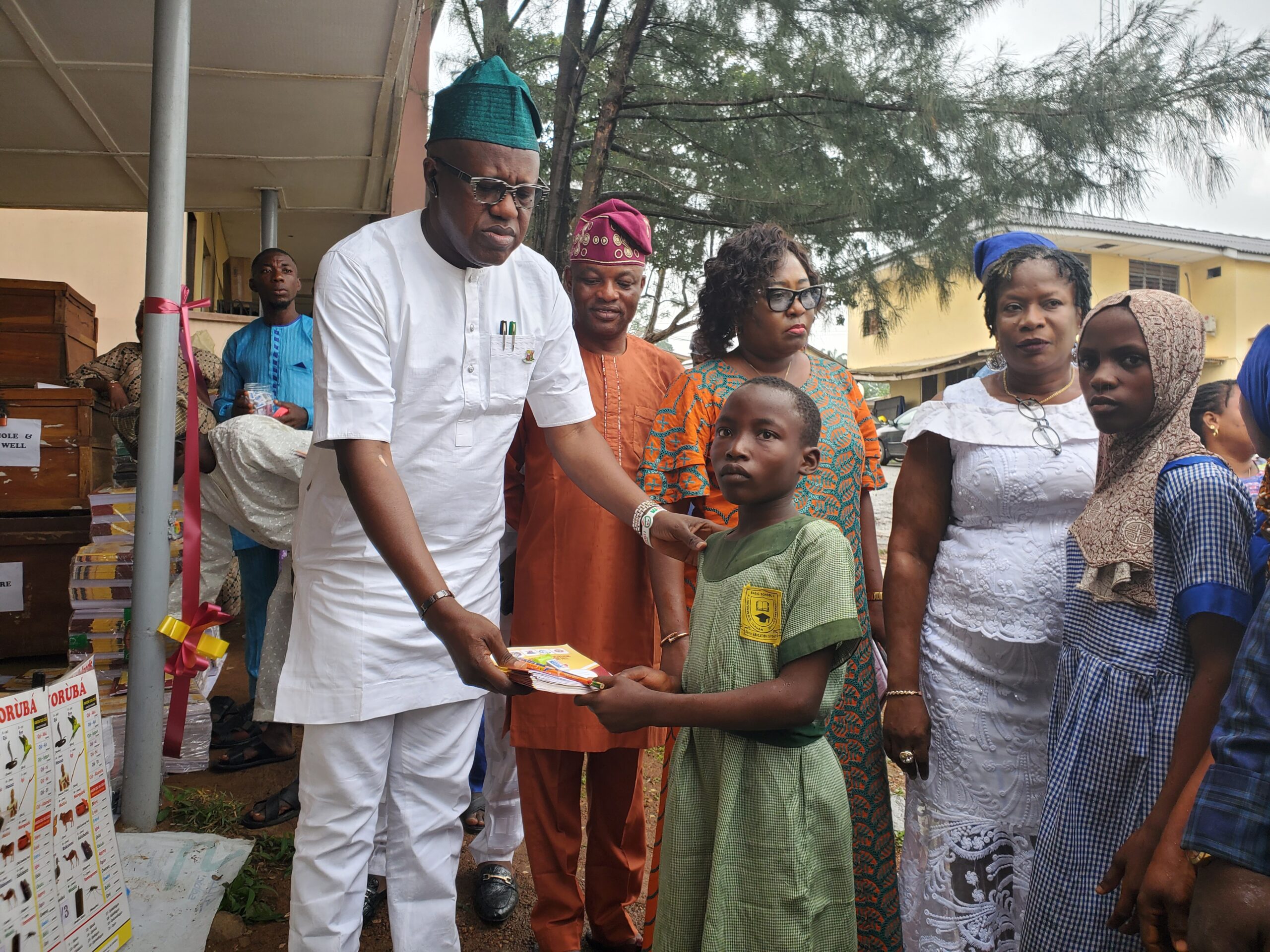 OYOSUBEB Chirman, Dr. Nureni Adeniran presenting writing materials to a pupil